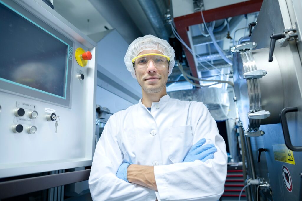 Portrait of male scientist with arms crossed in lab cleanroom