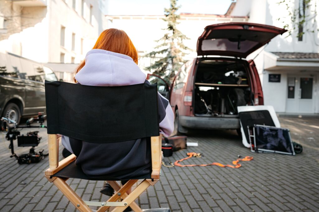 Young woman sits on director's chair on set